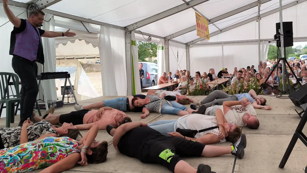 Des volontaires allongés sur scène sous hypnose pendant le spectacle de Nexus